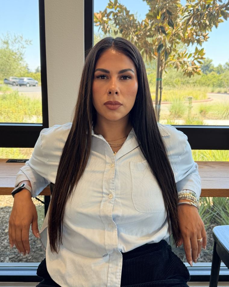 Ashley Bourgeois seated by a window, looking directly at the camera