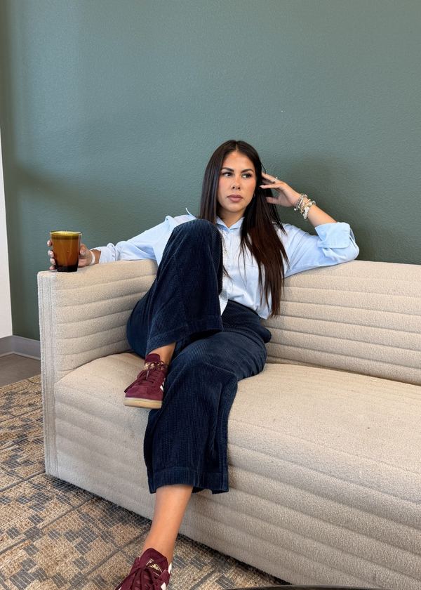 Ashley Bourgeois on a sofa with a coffee, in a quiet room with a green wall